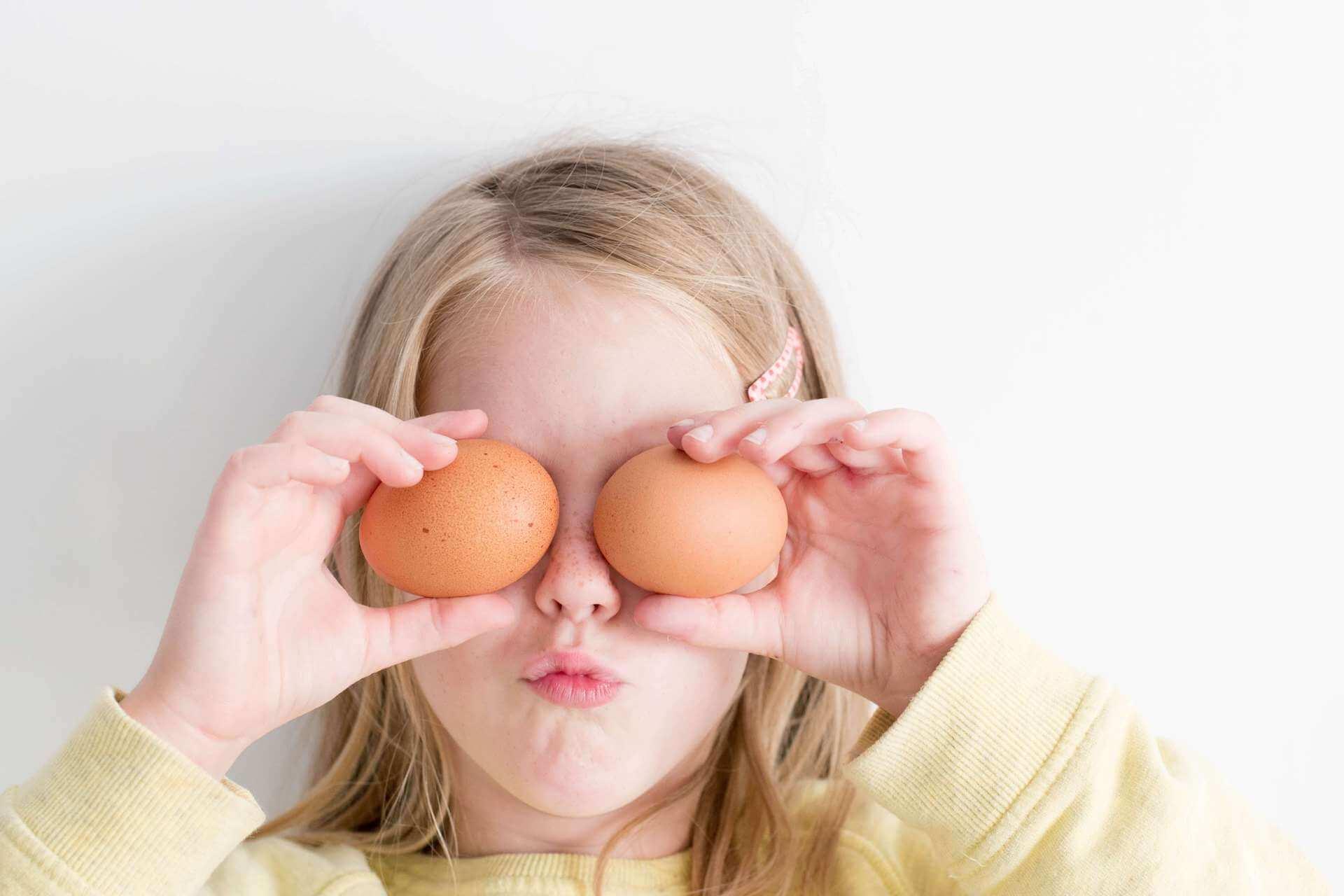 child holding eggs